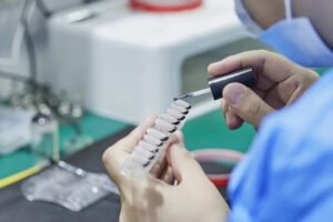 Lavara worker hand-painting a set of press-on nails with detailed color application.